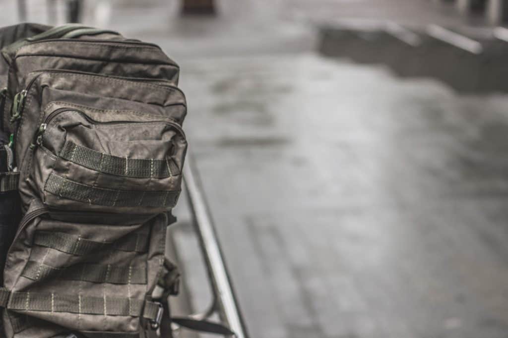 Tactical backpack on floor with molle attachments