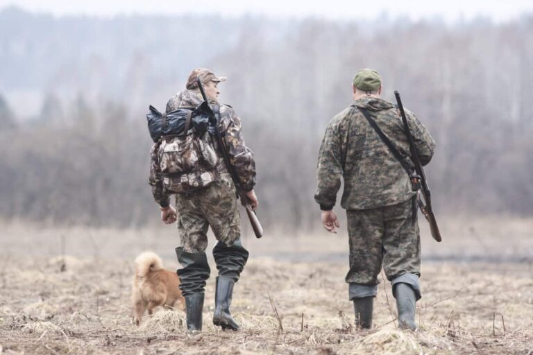 hunters walking through the woods carrying their hunting backpacks