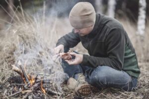 man in the wilderness cooking a bird on an open fire