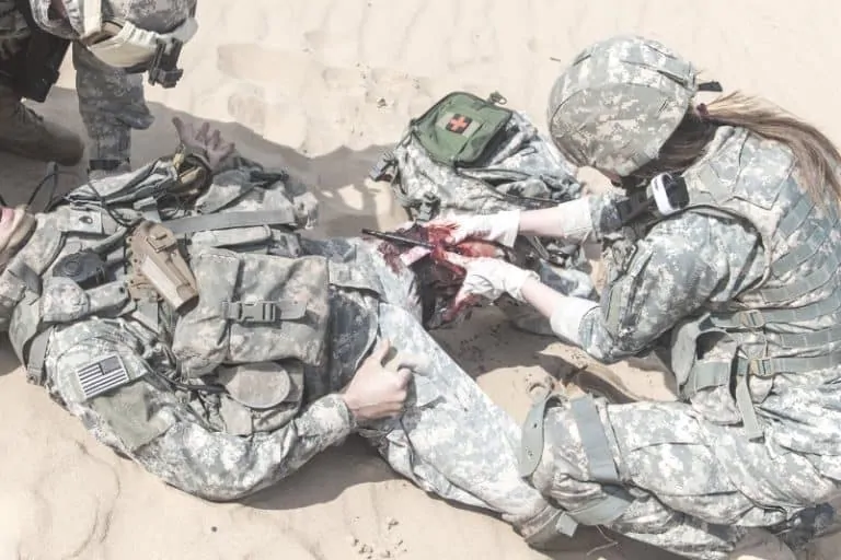 soldier is being rescued by medics using a tourniquet to stop the bleeding