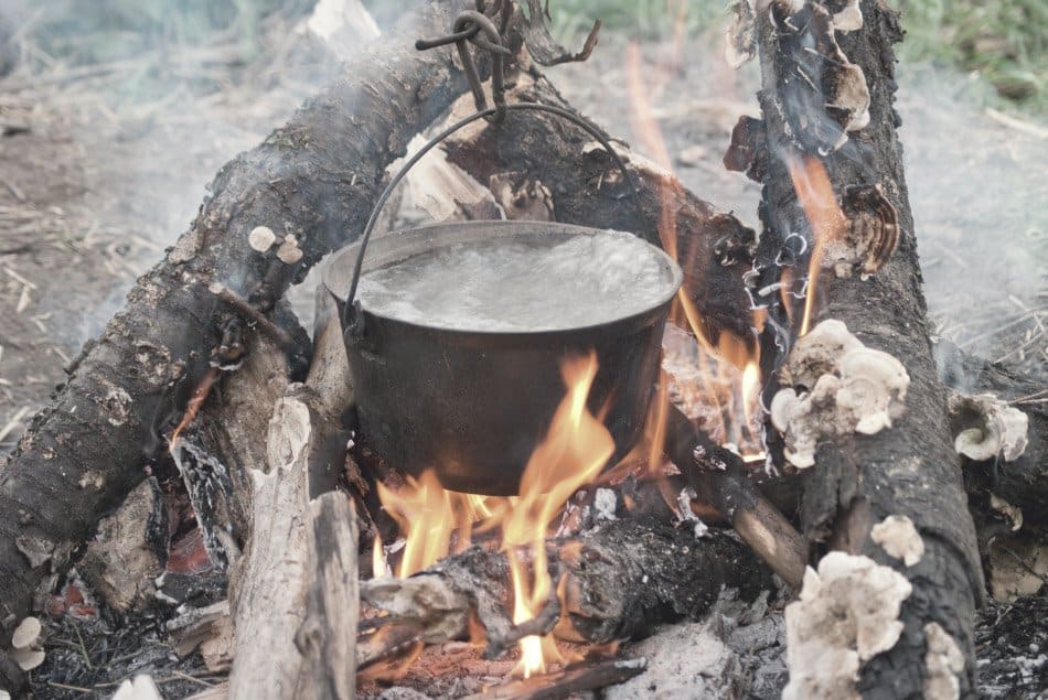 pot of boiling water over camping fire
