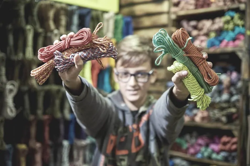 boy holding paracord bundles in hands in paracord store