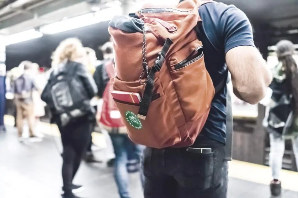 man waiting in underground, closeup of backpack
