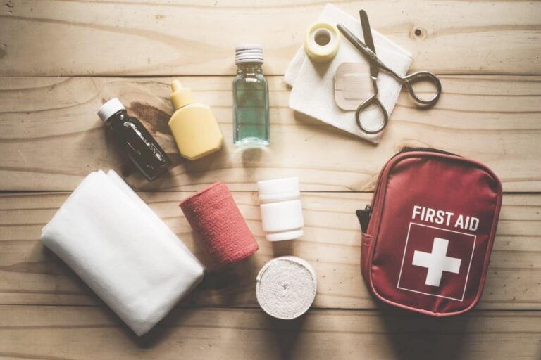first aid kit bag and emergency contents laid on table