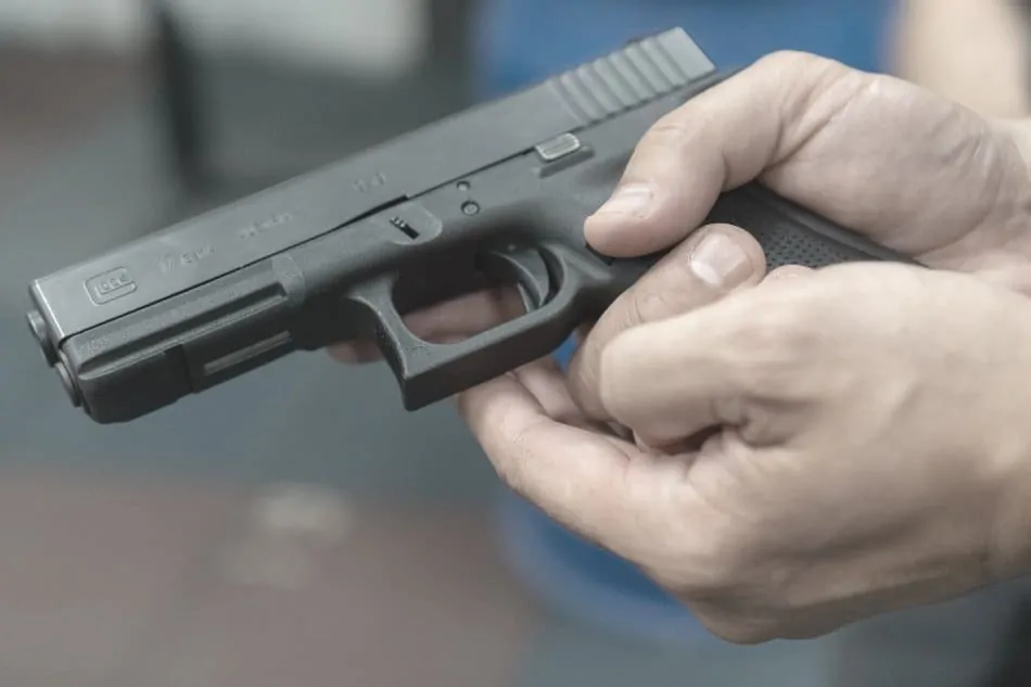 man holding glock 17 firearm in hands