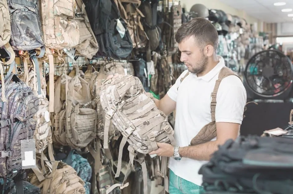 man holding backpack in store