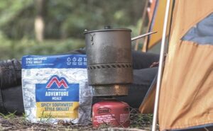 mountain house freeze dried meal pouch next to camping stove