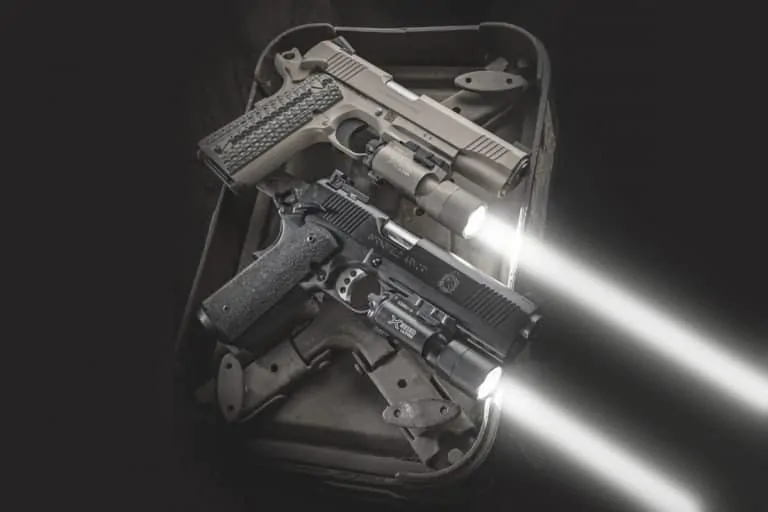 two handguns on a range bag with weapon lights fitted to the rail