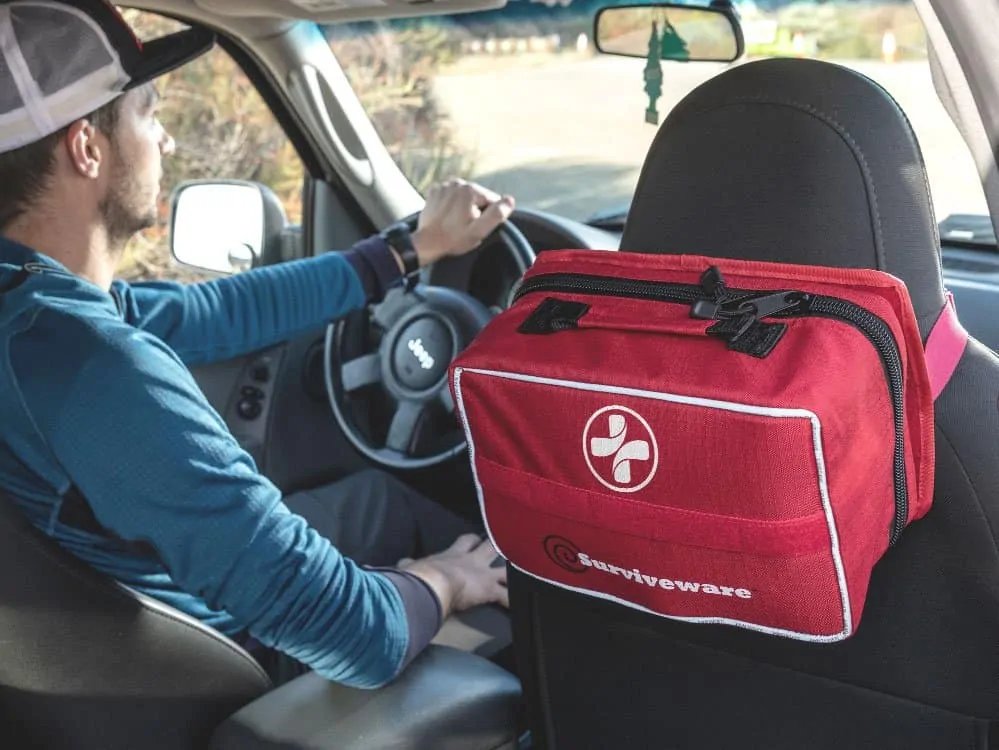 large first aid kit hung from car seat headrest