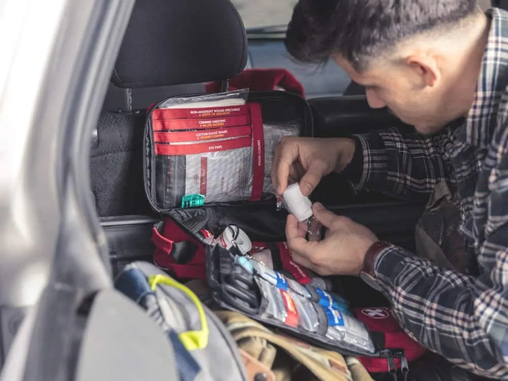 man looking for bandage in large first aid kit