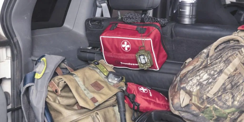 large first aid kit in trunk of car next to small first aid kit