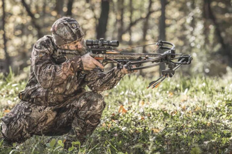 hunter in forest taking aim using the tenpoint invader x4 crossbow