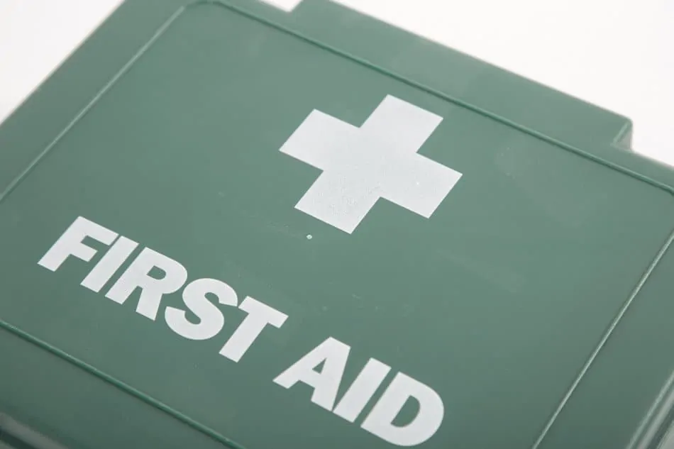 green plastic UK first aid box with white cross and first aid text