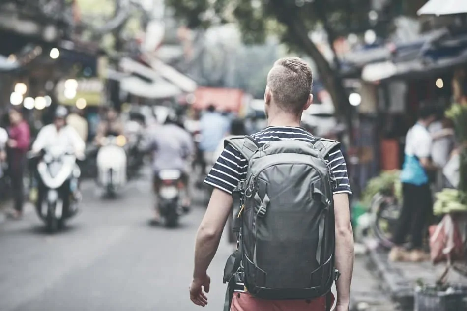 man walking in city with survival backpack