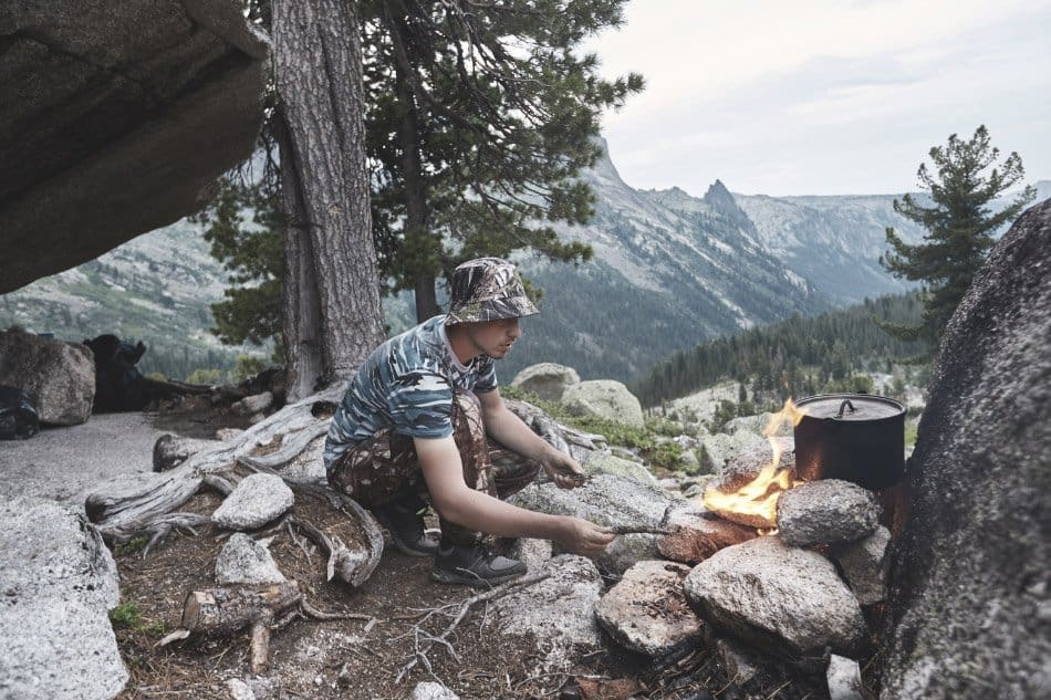 man built a campfire in the wilderness for survival