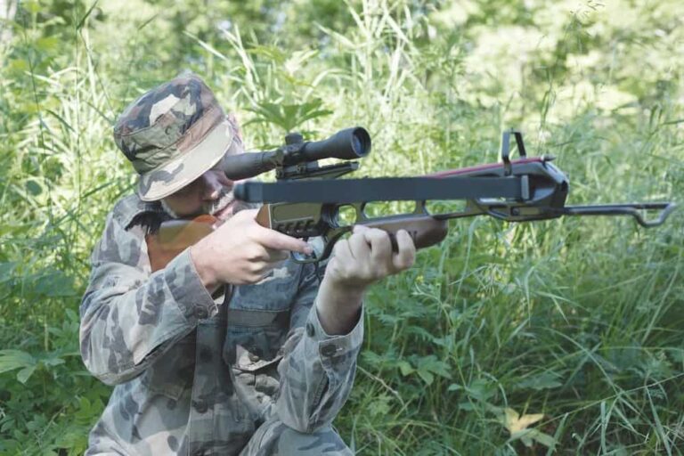 a hunter holding and firing a recurve crossbow outdoors