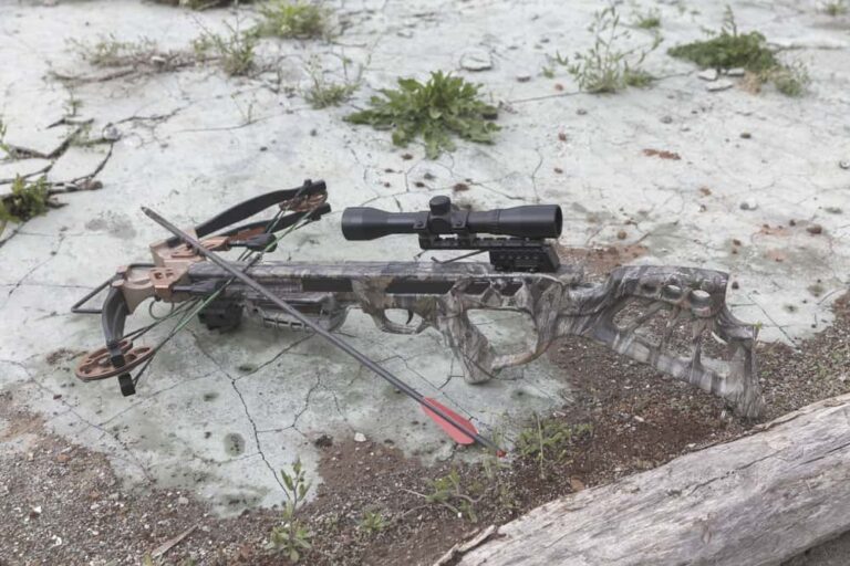 crossbow laid on ground in a safe position with arrows beside it
